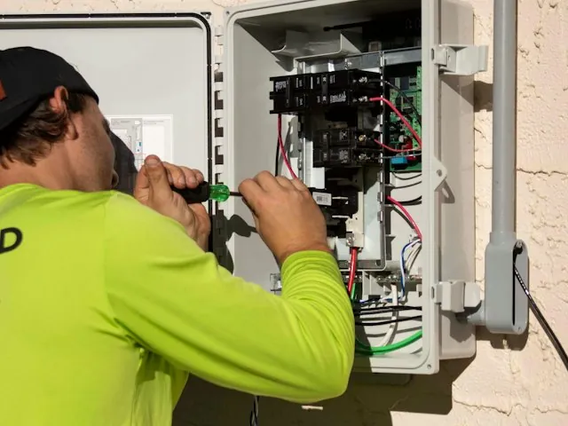 an electrician wiring an electrical panel