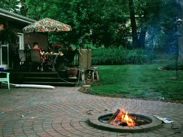 a backyard paver patio with a fire pit