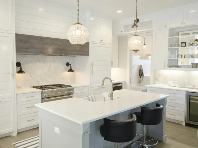 a newly remodeled white kitchen with an island